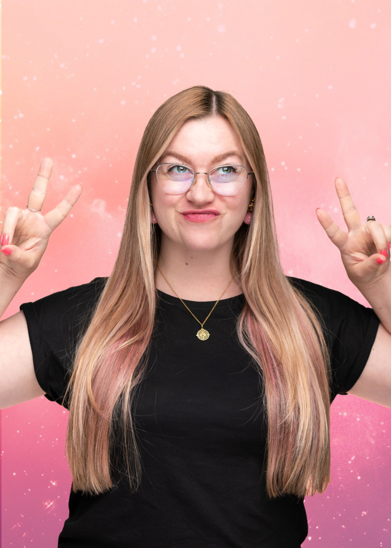 Pia Marlen Ungruh Soulful Branding & Design Lächelnde Frau mit langen, blonden Haaren und Brille, die mit den Händen ein Zeichen macht.